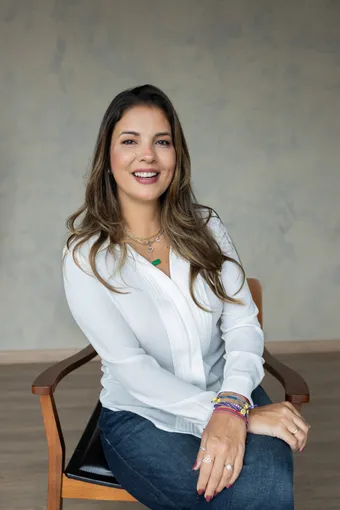 Cristina Senise, psicóloga, sorrindo, sentada.